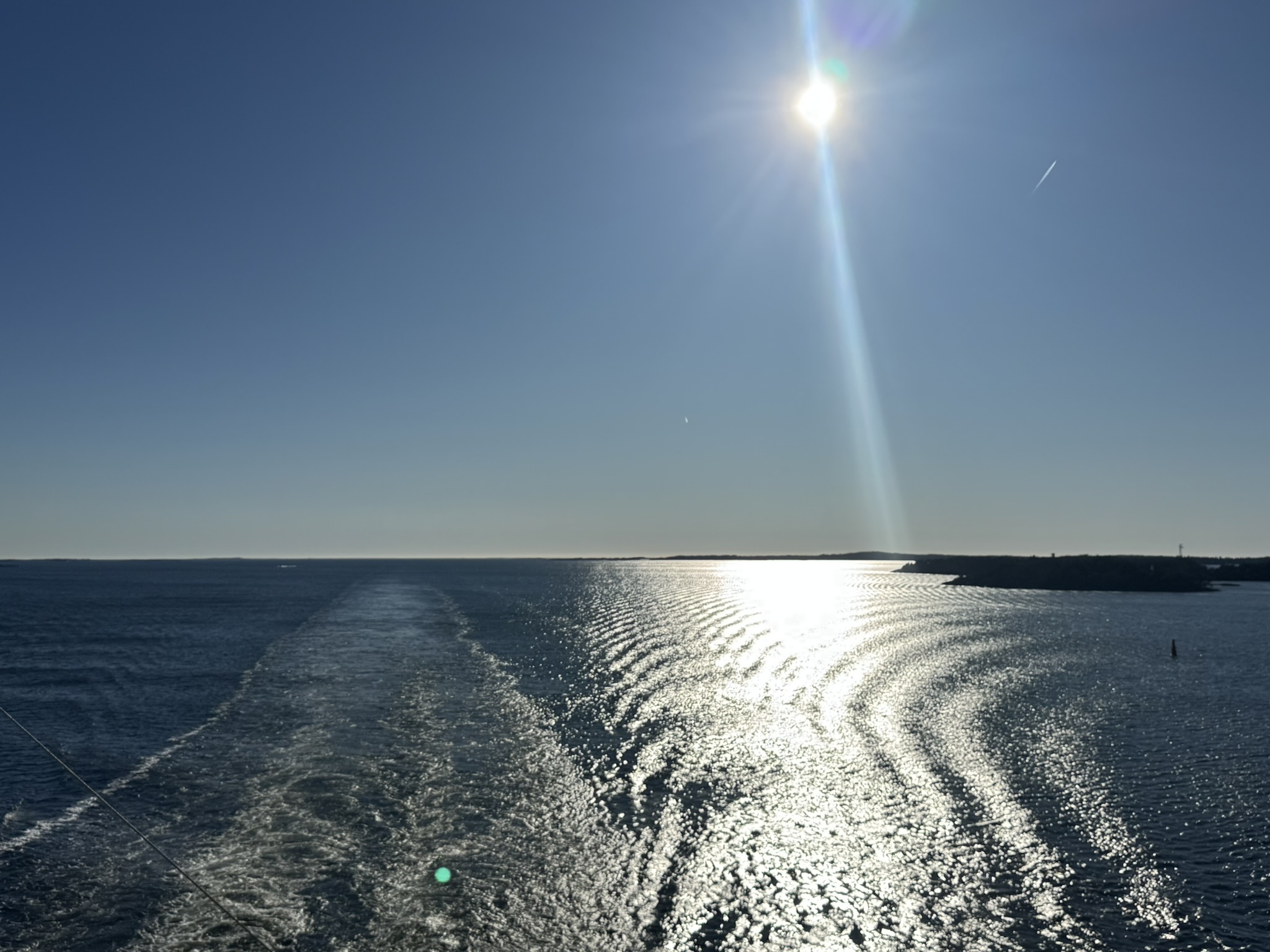 Veneen jättämä aallokko avomerellä auringonpaisteessa